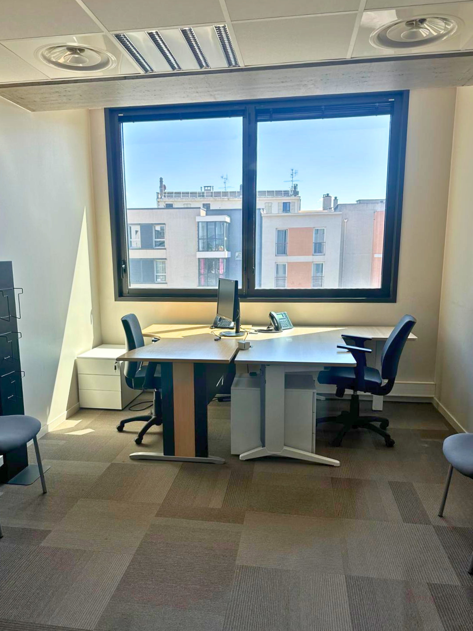 Bureau face à face devant une fenêtre ensoleillée