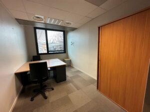 Office with two desks, chairs, and a large wooden sliding door.