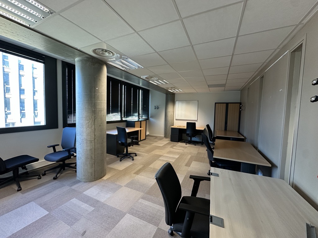 Office space with desks, chairs, and a whiteboard.