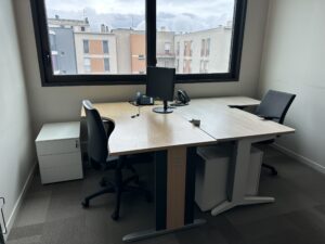 Office workspace with two desks, chairs, and a computer monitor.