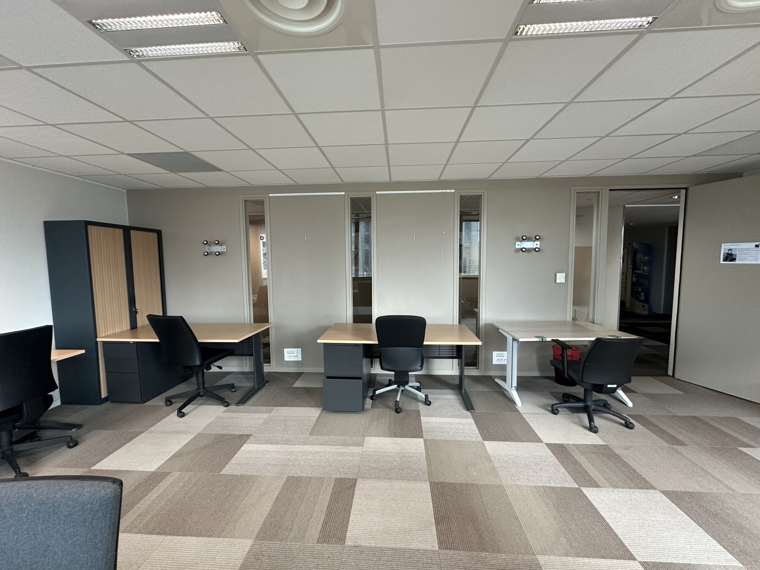 Office with multiple workstations, desks, and chairs.